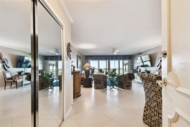 interior space with ceiling fan, crown molding, and light tile patterned floors