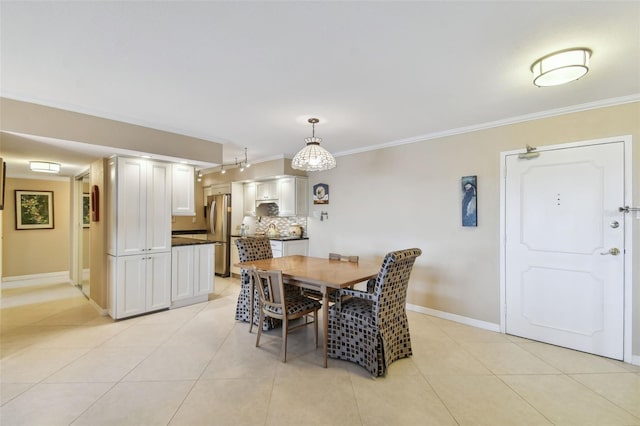 dining space with crown molding, baseboards, and light tile patterned flooring