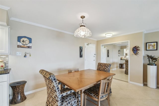 dining room featuring baseboards, ornamental molding, and light tile patterned flooring