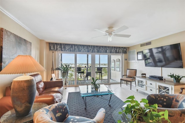 living area with visible vents, ornamental molding, ceiling fan, and light tile patterned flooring