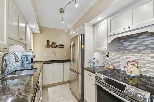 kitchen featuring white cabinets, sink, stainless steel appliances, dark stone counters, and decorative backsplash