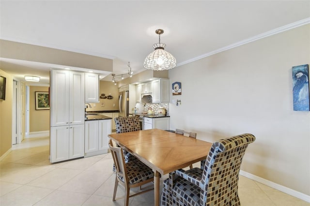 dining area featuring crown molding, baseboards, and light tile patterned floors
