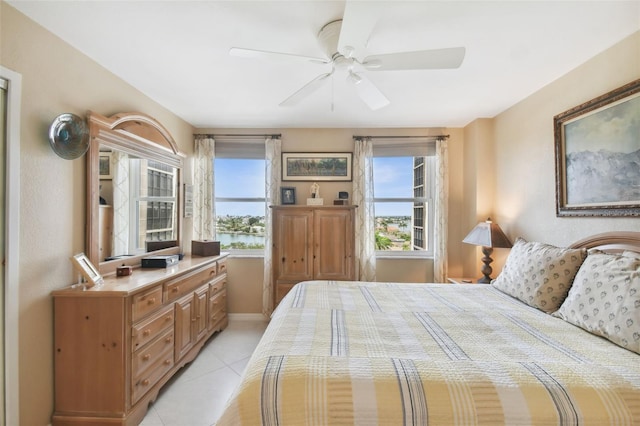 bedroom featuring a ceiling fan, baseboards, and light tile patterned floors