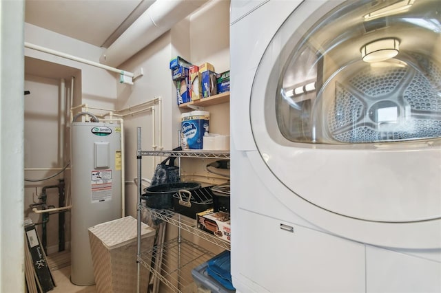 washroom featuring laundry area, stacked washer / dryer, and electric water heater