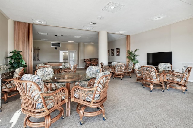 dining room with carpet floors, crown molding, and visible vents