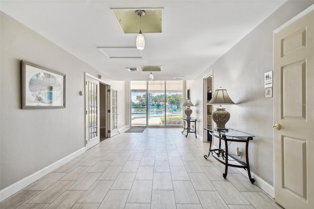 hallway featuring light hardwood / wood-style floors and a wall of windows