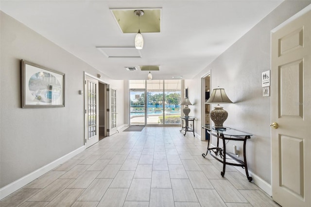 interior space featuring baseboards, visible vents, and a wall of windows