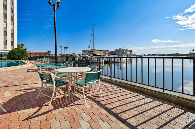 view of patio with a community pool and a water view