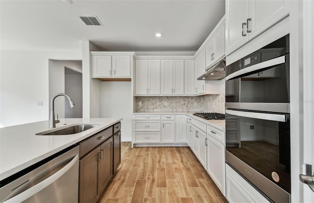 kitchen featuring white cabinets, backsplash, sink, and stainless steel appliances