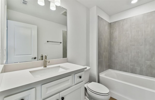 full bathroom with vanity, tiled shower / bath combo, and toilet