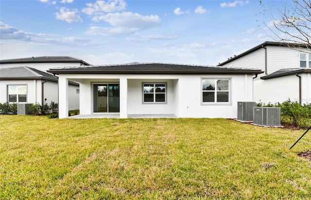 back of house with a lawn, a patio area, and central AC