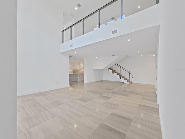 unfurnished living room featuring a high ceiling