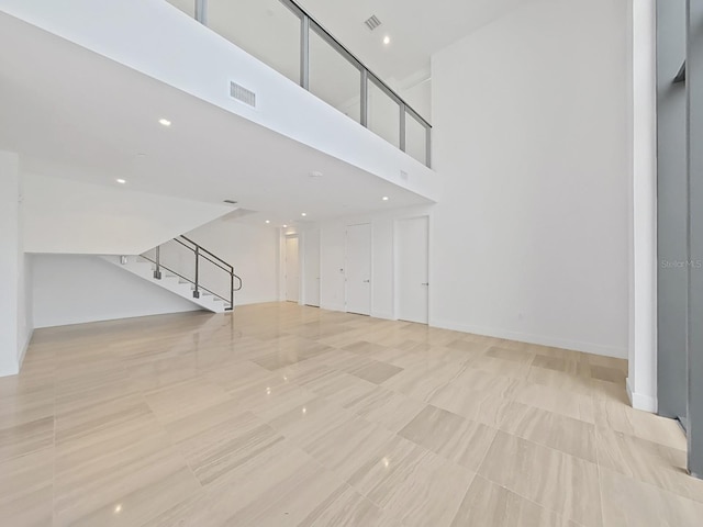 unfurnished living room featuring a high ceiling