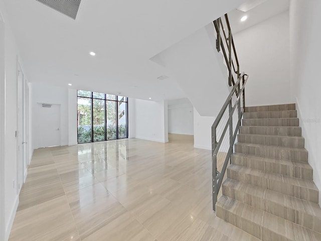 stairs featuring tile patterned flooring and expansive windows