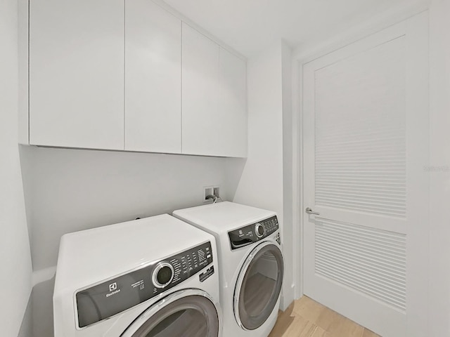 washroom with independent washer and dryer and cabinets