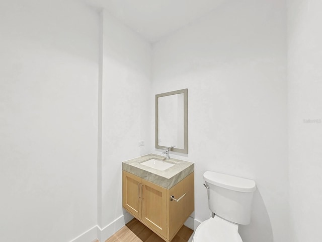 bathroom featuring vanity, toilet, and hardwood / wood-style flooring