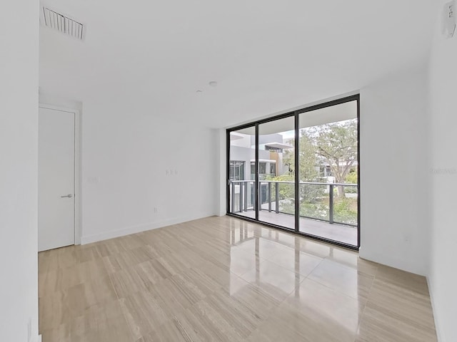 unfurnished room featuring light hardwood / wood-style flooring and floor to ceiling windows