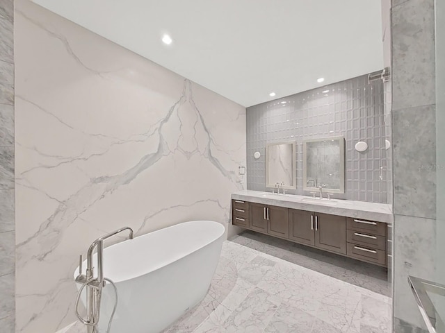 bathroom featuring a bathing tub, vanity, and tile walls