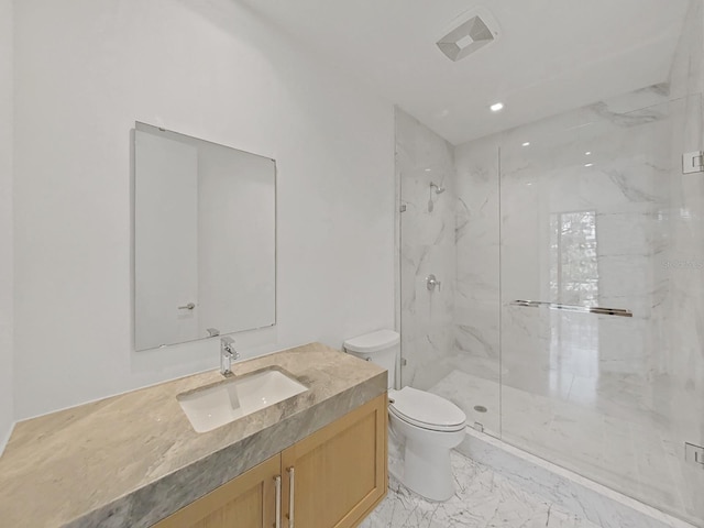 bathroom featuring a shower with door, vanity, and toilet