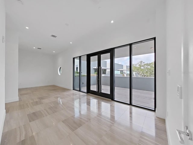 empty room with french doors and light tile patterned floors