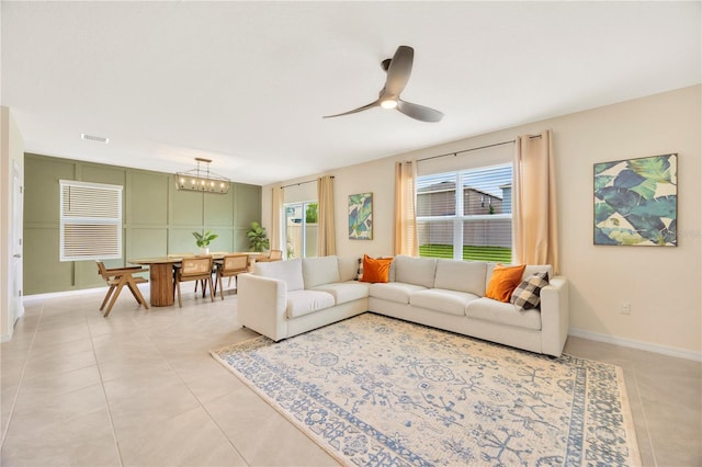 living room with ceiling fan with notable chandelier and light tile patterned floors