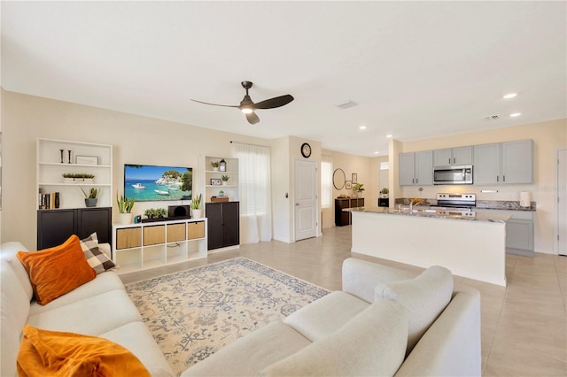 tiled living room with ceiling fan