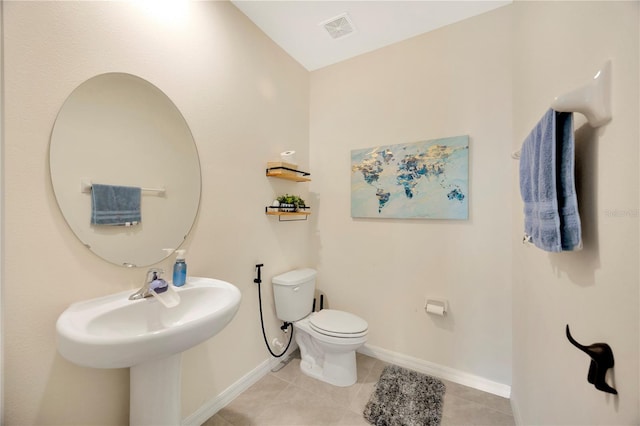 bathroom with lofted ceiling, toilet, and tile patterned floors