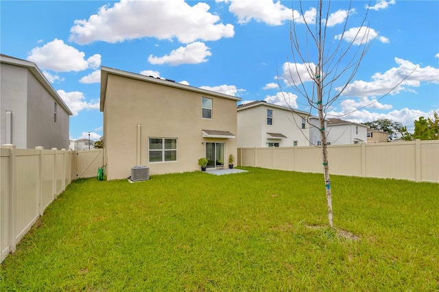 rear view of property featuring a patio area, a lawn, and central air condition unit