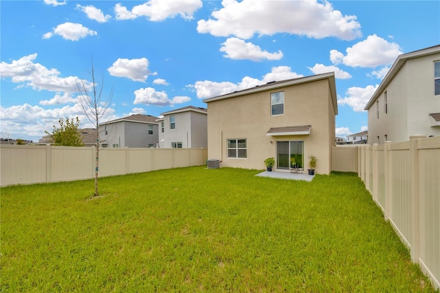 rear view of property featuring central AC and a yard