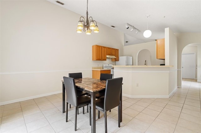 dining area with light tile patterned floors, sink, a chandelier, and rail lighting