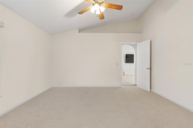 carpeted empty room with a textured ceiling, lofted ceiling, and ceiling fan