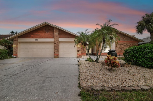 view of front of home with a garage, brick siding, and concrete driveway