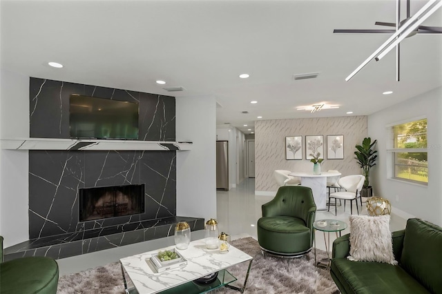 living room with ceiling fan and a premium fireplace