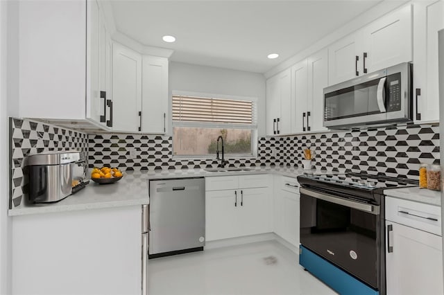 kitchen with sink, white cabinetry, tasteful backsplash, appliances with stainless steel finishes, and light stone countertops