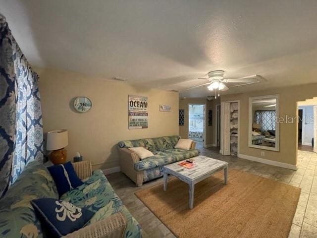 living room featuring light tile patterned floors and ceiling fan