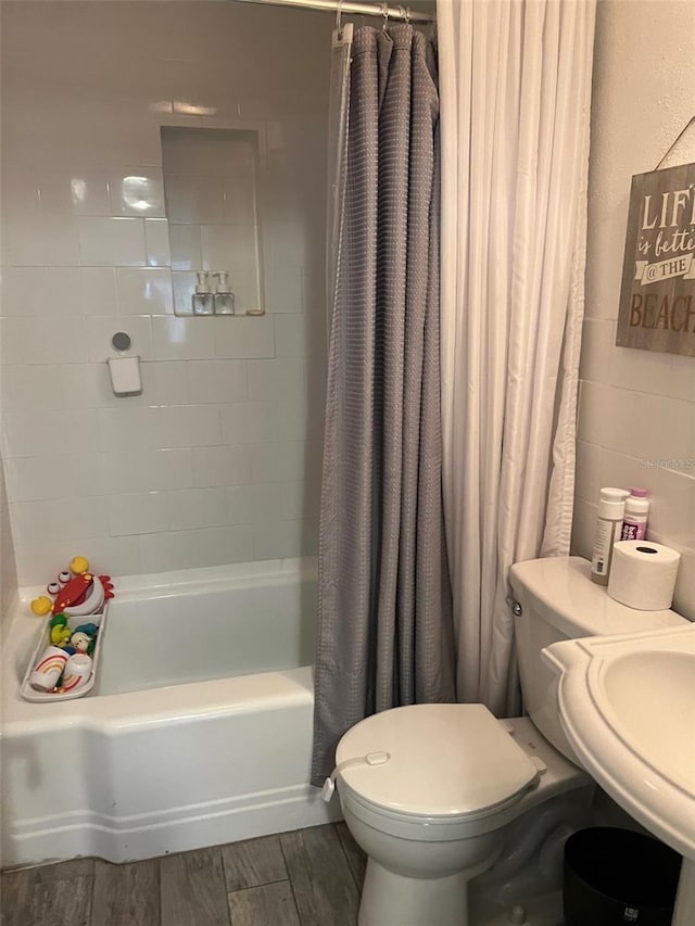 bathroom featuring toilet, hardwood / wood-style floors, and shower / tub combo with curtain