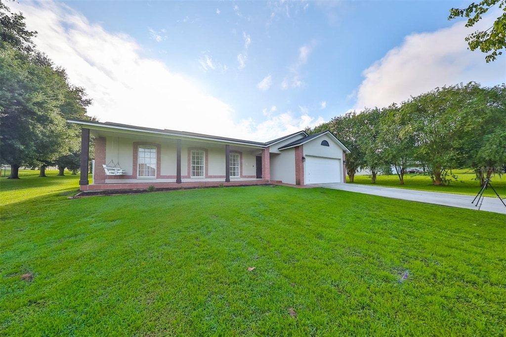 single story home with a garage, a front lawn, and a porch