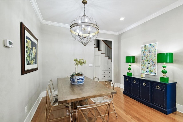 dining space with hardwood / wood-style flooring, an inviting chandelier, and crown molding