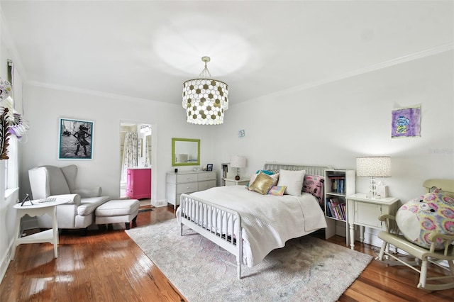 bedroom featuring ornamental molding, wood-type flooring, and a chandelier