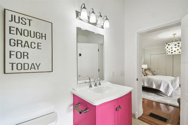 bathroom with vanity, toilet, and hardwood / wood-style floors