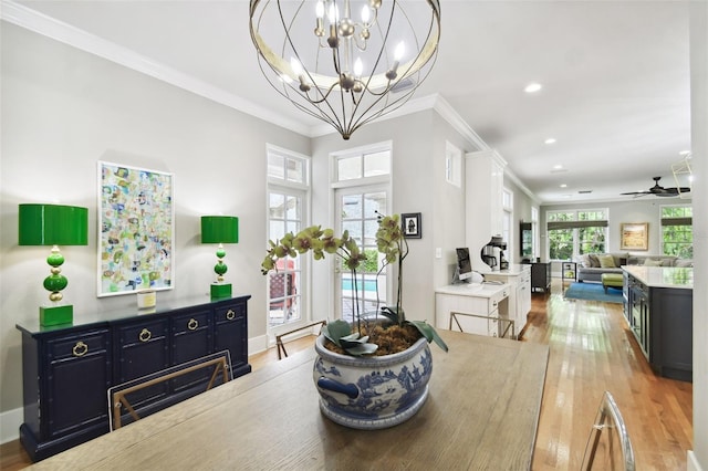 dining space with ceiling fan with notable chandelier, light hardwood / wood-style floors, and ornamental molding