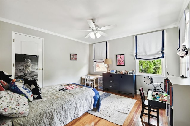 bedroom featuring ceiling fan, crown molding, and wood-type flooring