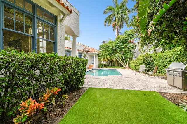 view of swimming pool featuring area for grilling and a patio