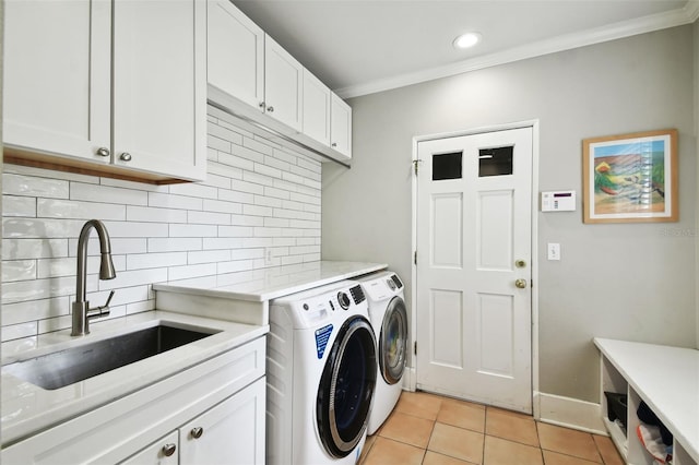 laundry room with light tile patterned floors, independent washer and dryer, sink, cabinets, and ornamental molding