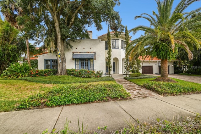 mediterranean / spanish-style house featuring a front lawn and a garage