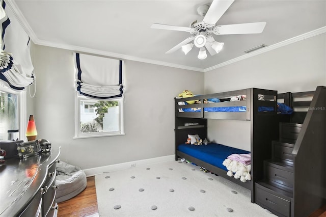 bedroom with multiple windows, ceiling fan, and ornamental molding