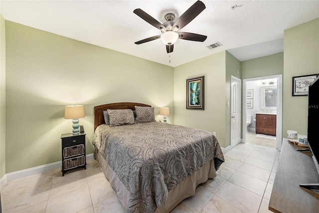 bedroom with ensuite bathroom, light tile patterned floors, and ceiling fan