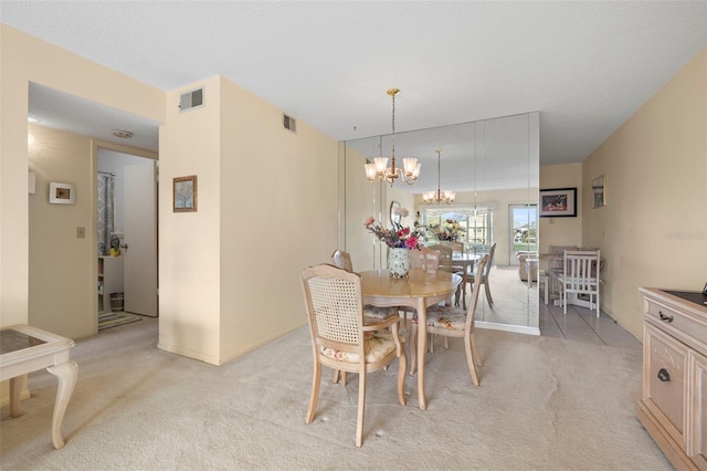 carpeted dining room featuring a notable chandelier and a textured ceiling