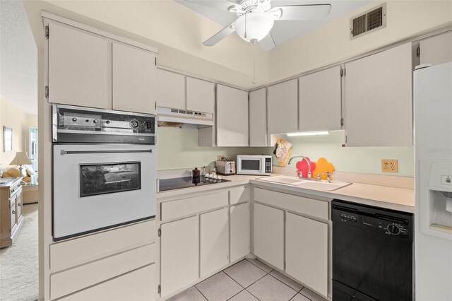 kitchen featuring white cabinets, sink, black appliances, light tile patterned flooring, and ceiling fan