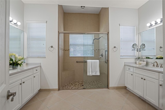 bathroom featuring tile patterned floors, vanity, a wealth of natural light, and a shower with shower door